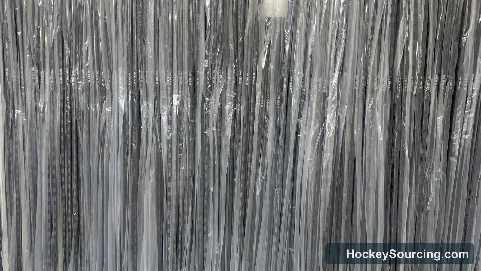 Grouped blank hockey sticks individually protected in clear sleeves